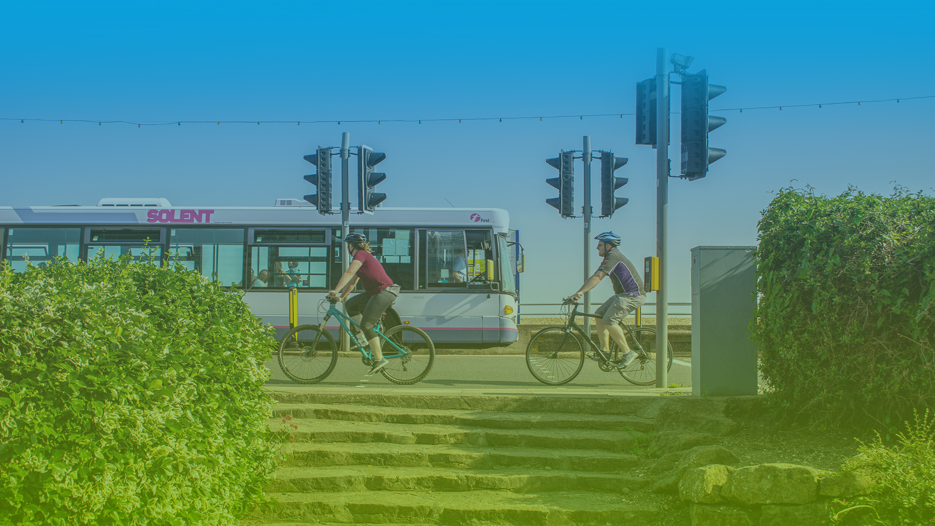 Image of cyclists and bus by a traffic light